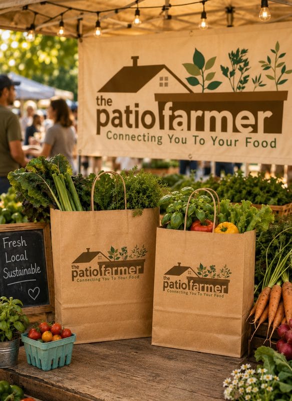 Farmers market booth mockup featuring The Patio Farmer logo displayed on a banner and kraft paper produce bags surrounded by fresh vegetables and greenery.