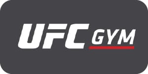 Small UFC Gym logo with bold white lettering and red underline accent on dark gray background